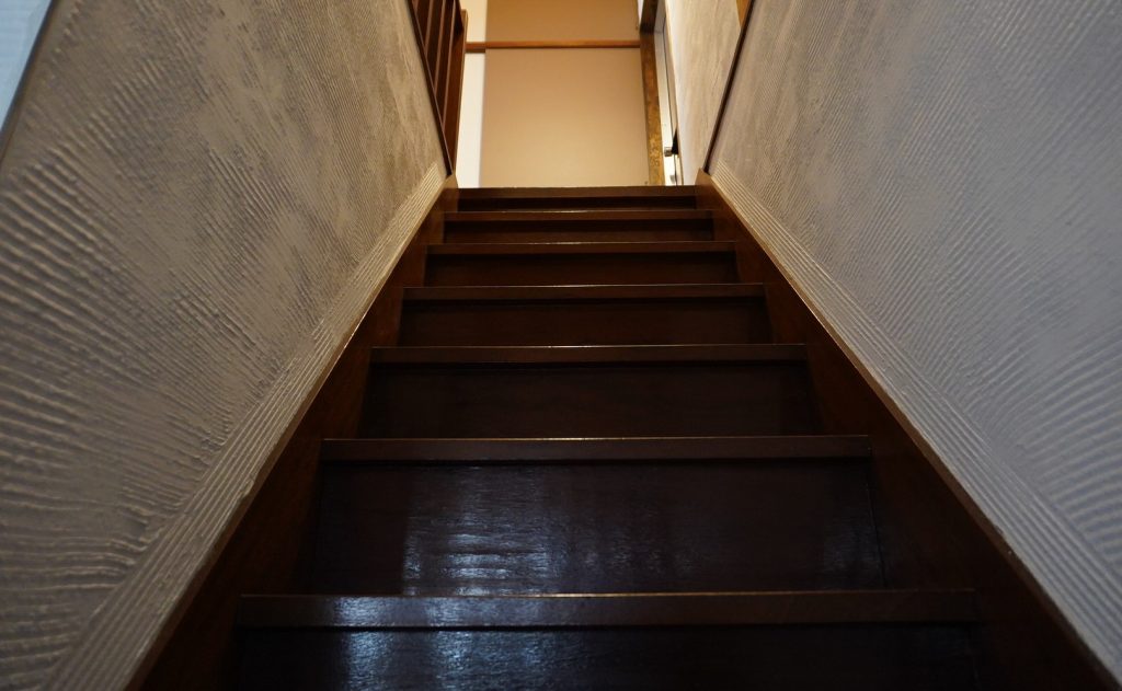 下から見上げた木の階段と白い漆喰の壁