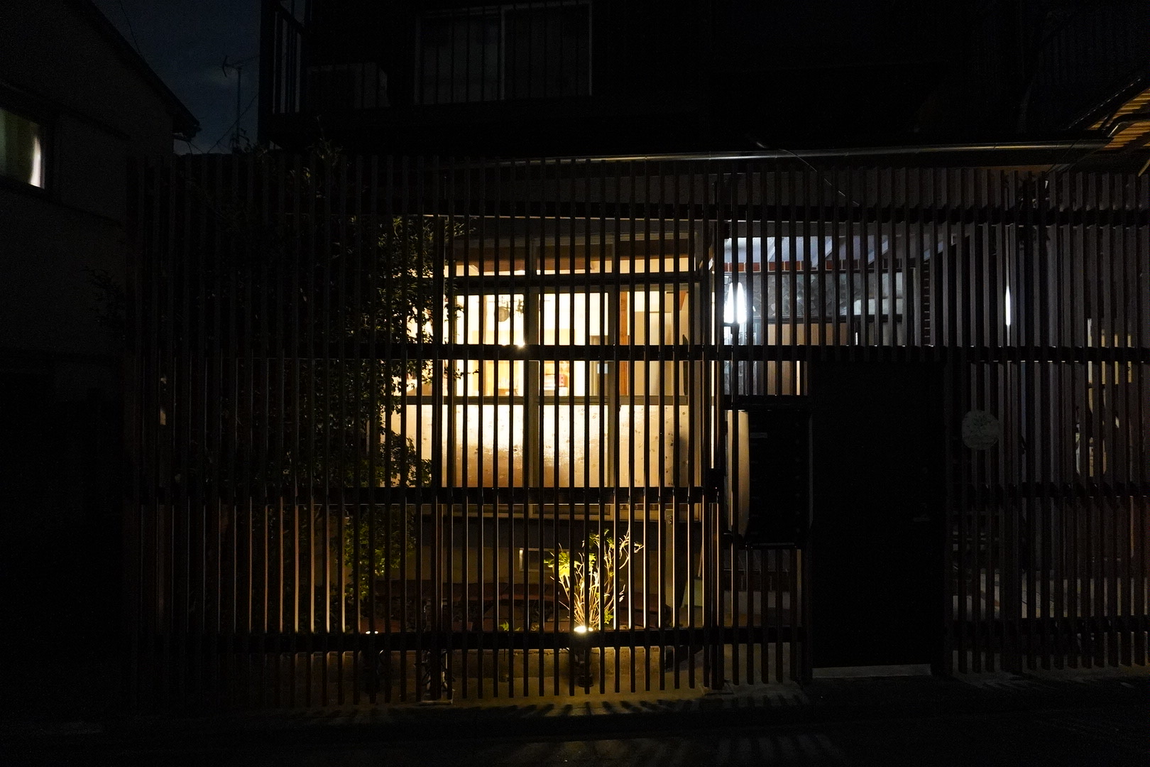 夜、木の格子ごしに窓の灯りがともるMother TREEの外観